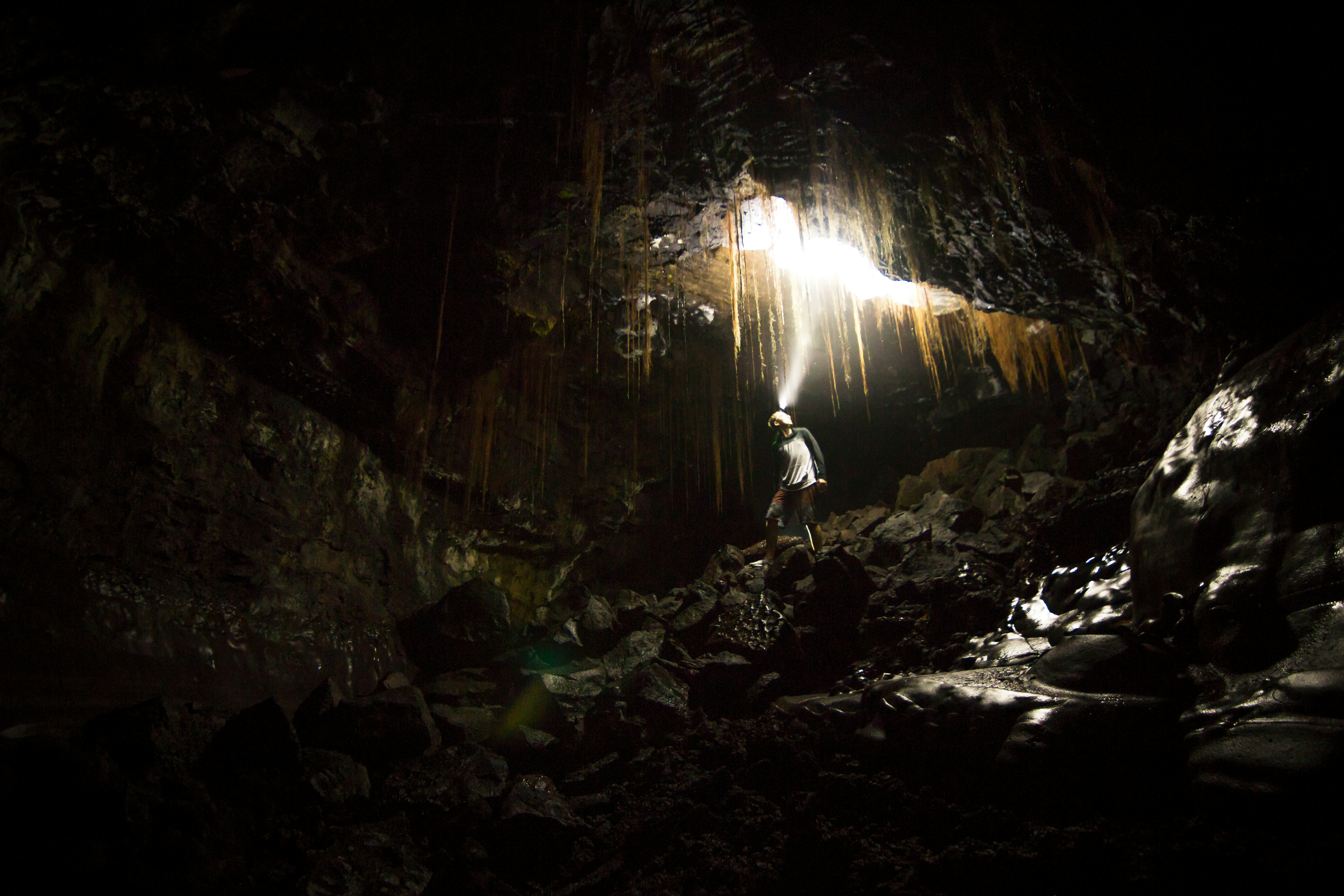 man walking on brown cave racks